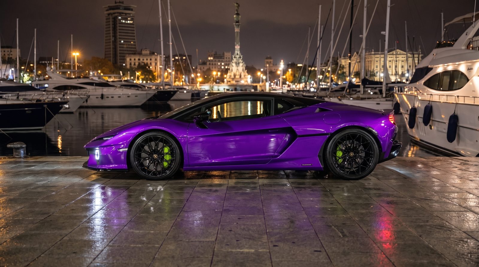 Temerario morado en el muelle del Port Vell de noche con el monumento a Colón